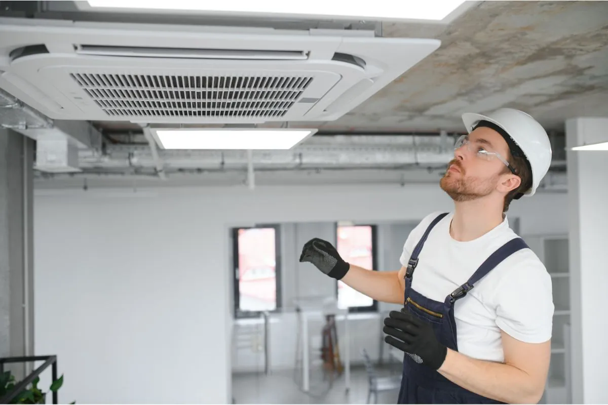 male technician repairing commercial ceiling air conditioning unit in Albuquerque NM