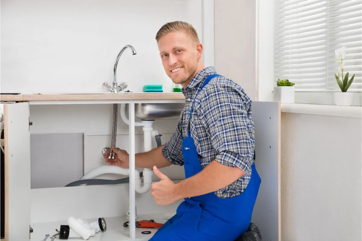 plumber repairing kitchen faucet