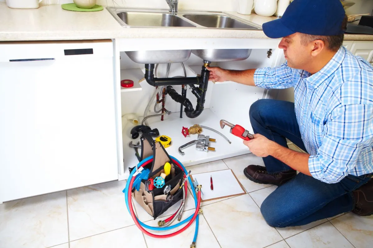 plumber on the kitchen with tools