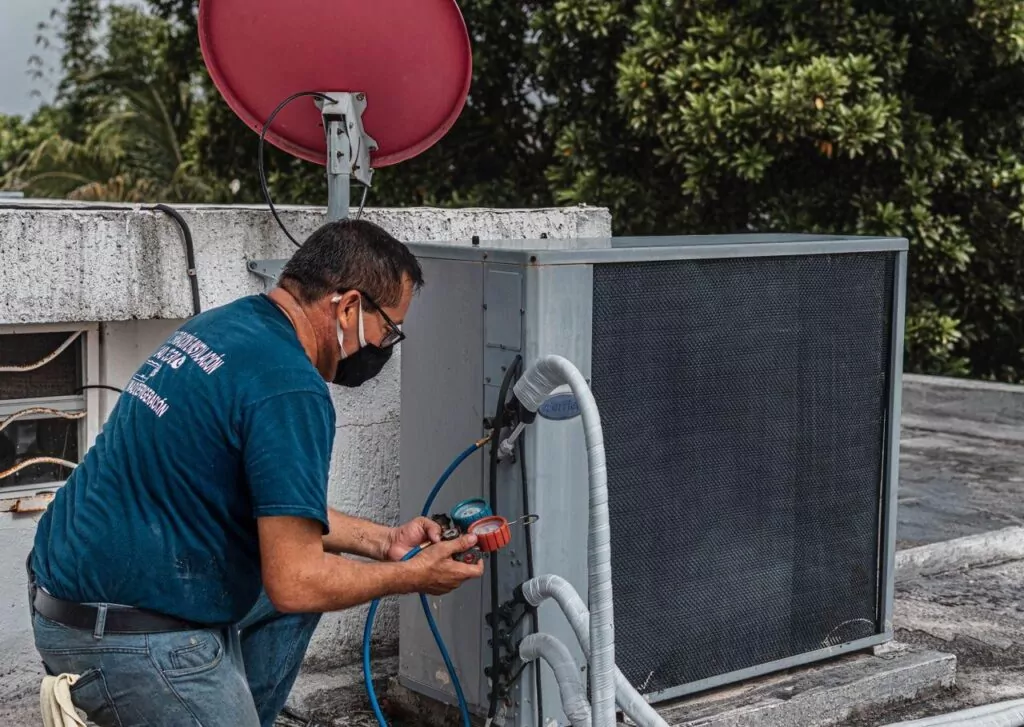 HVAC technician servicing an outdoor AC condenser unit